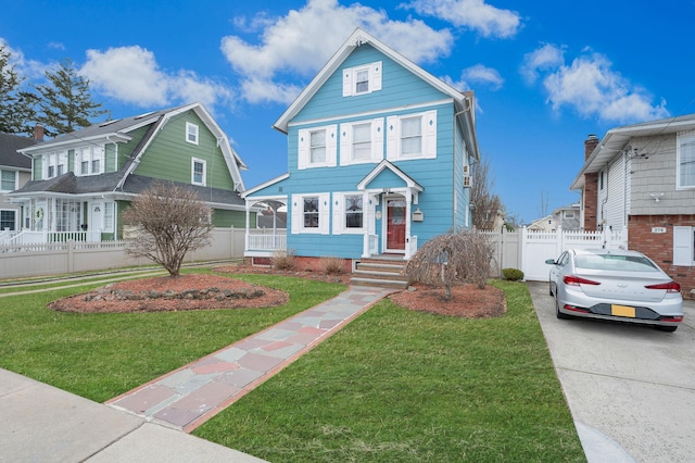 view of front facade with a front lawn, fence, and a residential view