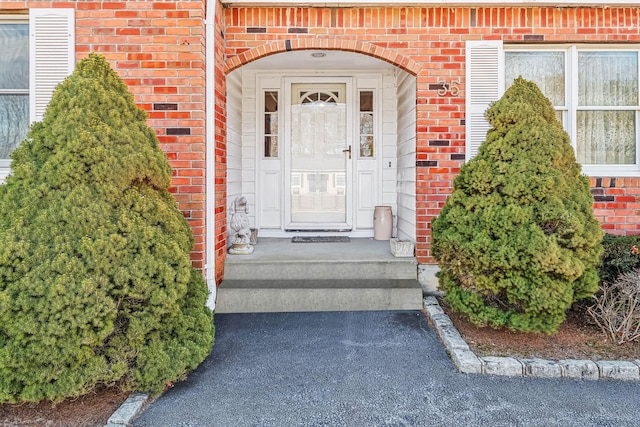 doorway to property featuring brick siding