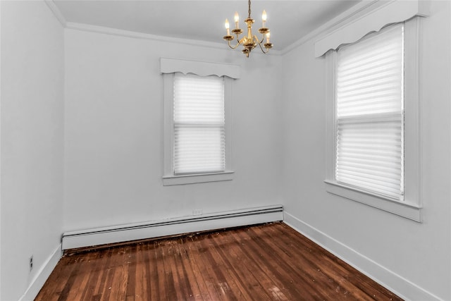 spare room featuring ornamental molding, baseboard heating, wood finished floors, and baseboards