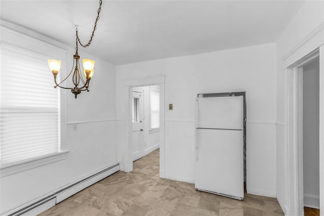 unfurnished dining area featuring baseboard heating and an inviting chandelier