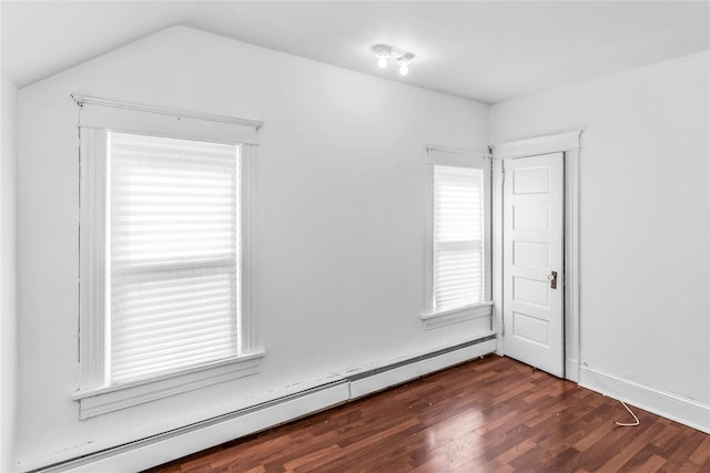 empty room with a baseboard heating unit, lofted ceiling, and dark wood finished floors