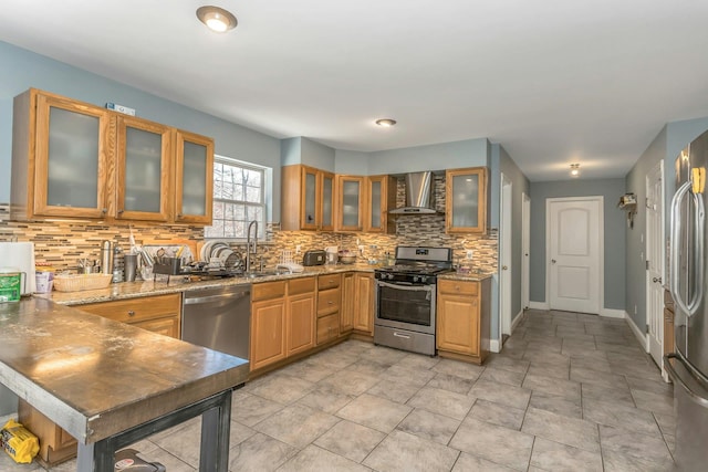 kitchen with stainless steel appliances, backsplash, light stone countertops, wall chimney exhaust hood, and glass insert cabinets