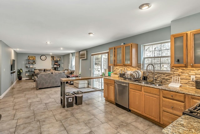 kitchen featuring backsplash, glass insert cabinets, a sink, light stone countertops, and dishwasher