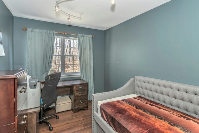 bedroom featuring track lighting and wood finished floors