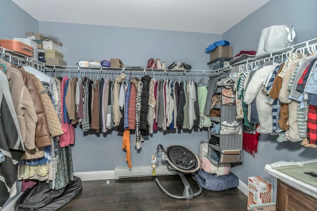 spacious closet featuring a baseboard heating unit and dark wood finished floors