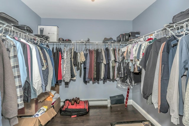 walk in closet with baseboard heating and wood finished floors