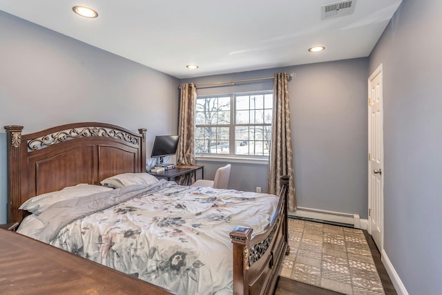 bedroom featuring a baseboard heating unit, recessed lighting, visible vents, and baseboards