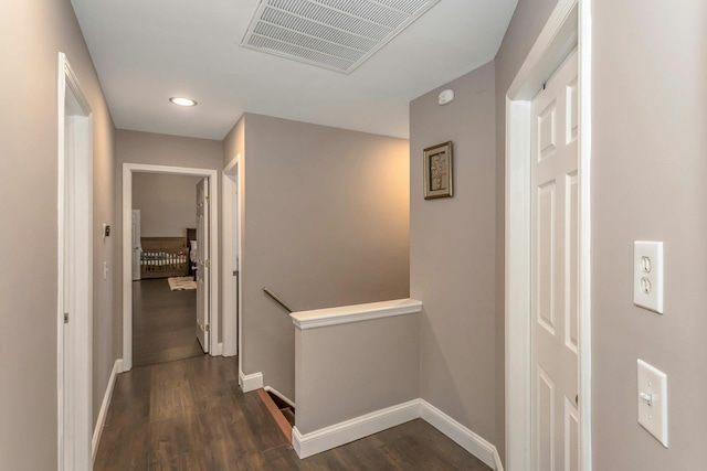 corridor featuring recessed lighting, dark wood-style flooring, visible vents, an upstairs landing, and baseboards