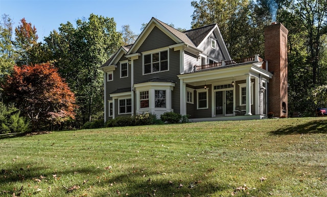 view of front facade with a front lawn, a chimney, and a balcony