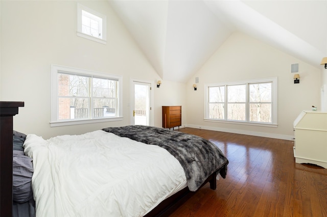 bedroom with high vaulted ceiling, dark wood finished floors, and baseboards