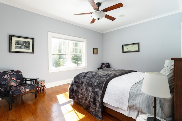 bedroom with ornamental molding, ceiling fan, and wood finished floors