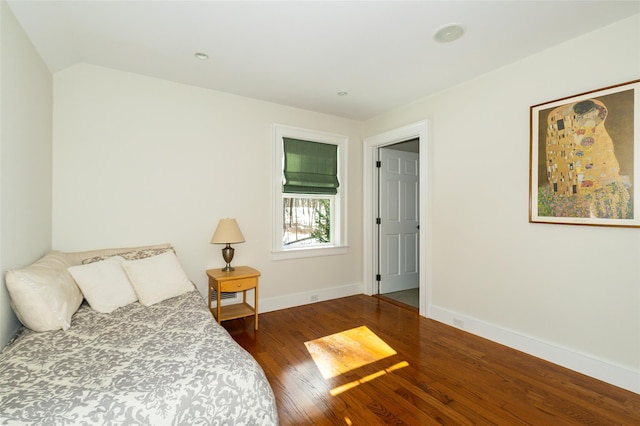 bedroom featuring wood finished floors, visible vents, and baseboards