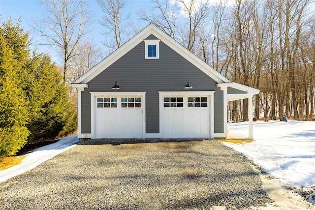 snow covered garage with a detached garage