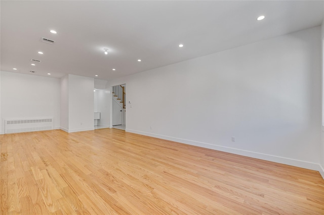 unfurnished room featuring recessed lighting, visible vents, light wood finished floors, and stairs