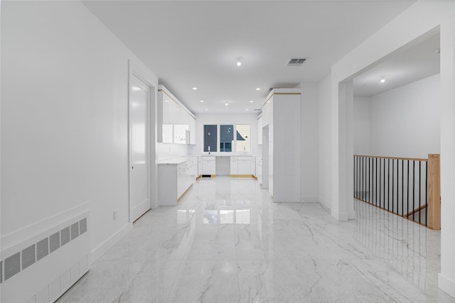 empty room featuring recessed lighting, visible vents, baseboards, marble finish floor, and radiator heating unit