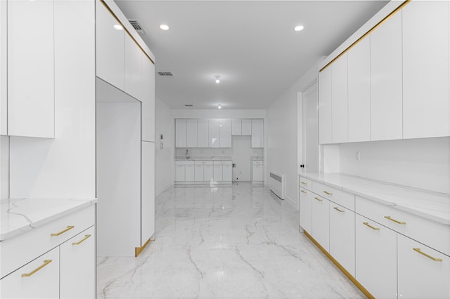 kitchen featuring visible vents, modern cabinets, light stone countertops, marble finish floor, and white cabinetry