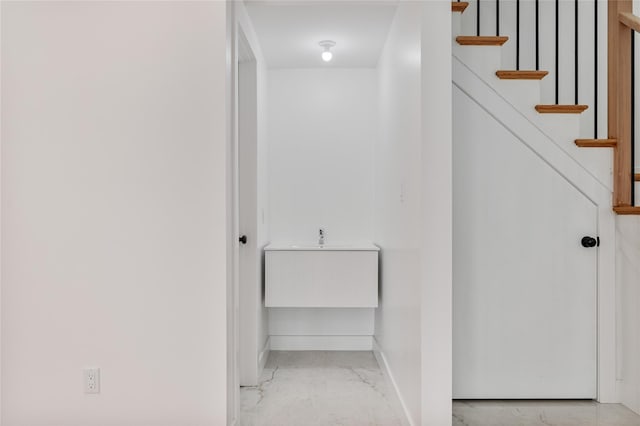 interior space featuring marble finish floor, stairway, and baseboards