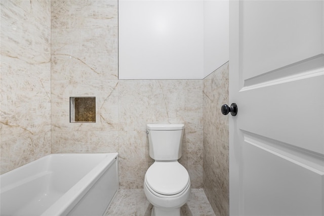 bathroom featuring a tub to relax in, tile walls, and toilet