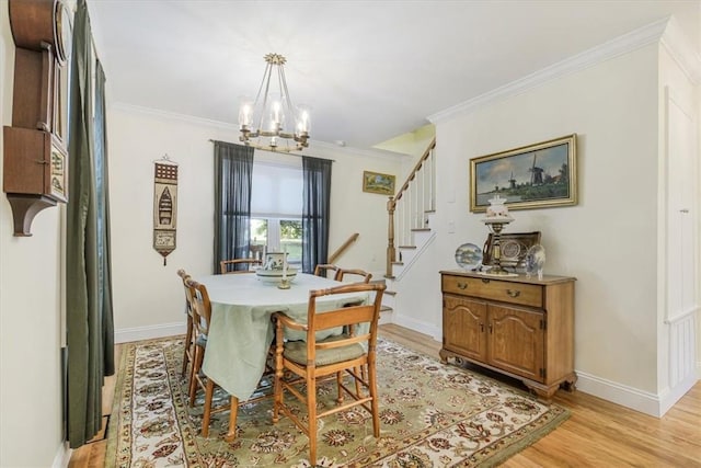 dining area with crown molding, stairway, light wood finished floors, and a chandelier