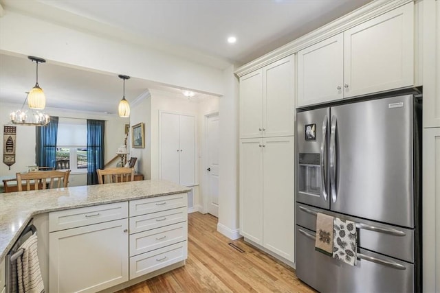 kitchen with light wood-type flooring, light stone counters, stainless steel appliances, white cabinets, and hanging light fixtures