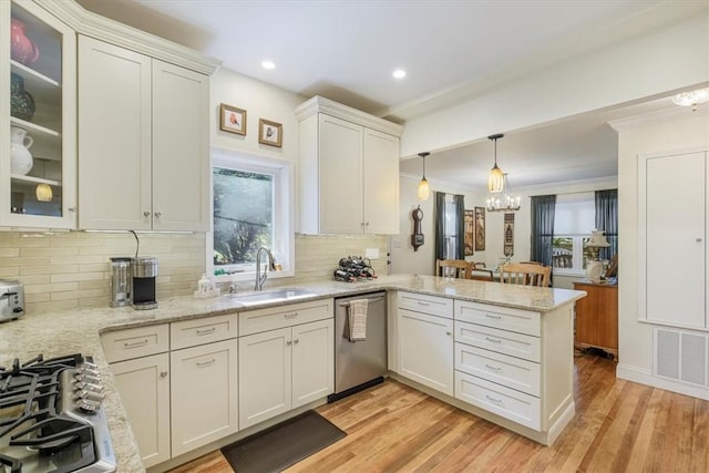 kitchen with visible vents, a sink, stainless steel appliances, a peninsula, and light wood finished floors