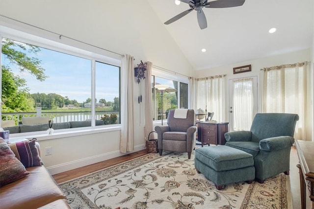 living room featuring high vaulted ceiling, wood finished floors, baseboards, and ceiling fan