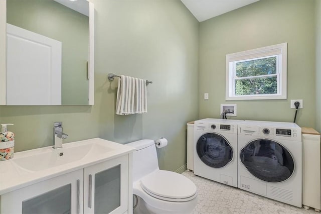 laundry room with laundry area, independent washer and dryer, and a sink