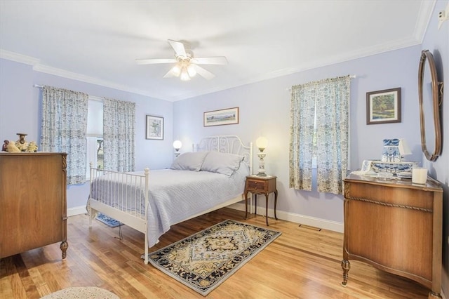 bedroom with crown molding, wood finished floors, baseboards, and ceiling fan