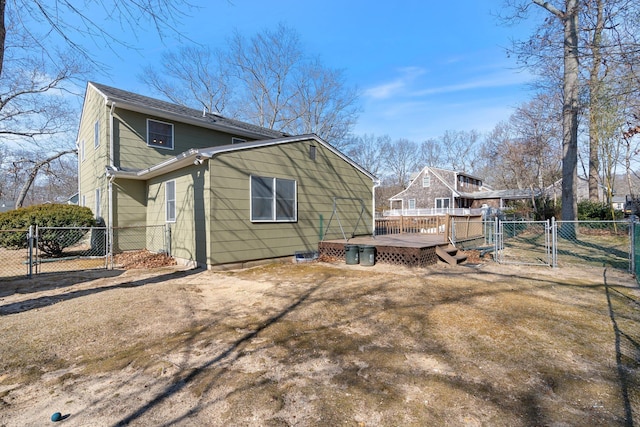 back of house featuring a wooden deck, a gate, and fence