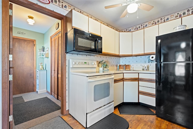 kitchen with white cabinets, light wood-style flooring, light countertops, black appliances, and a sink