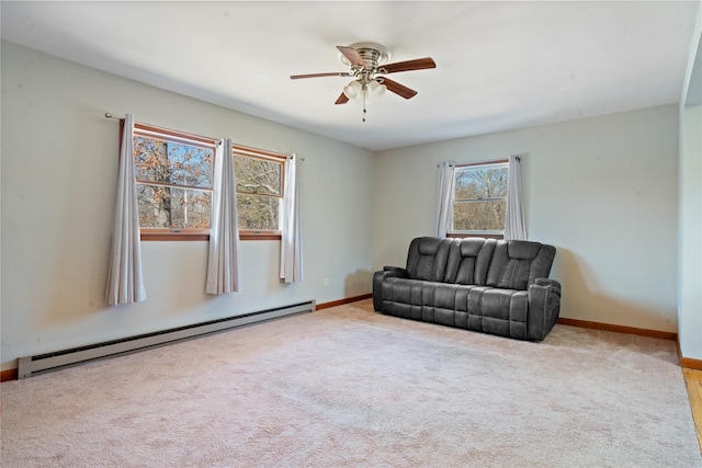 living area featuring a baseboard heating unit, carpet floors, a ceiling fan, and baseboards