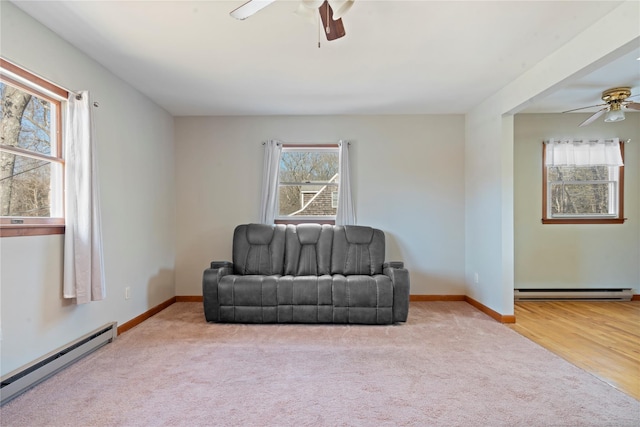 living area featuring carpet, ceiling fan, and baseboard heating