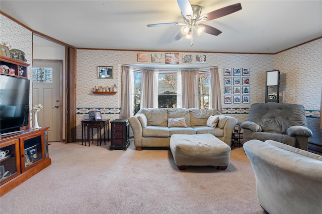 carpeted living area featuring a ceiling fan, crown molding, and wallpapered walls