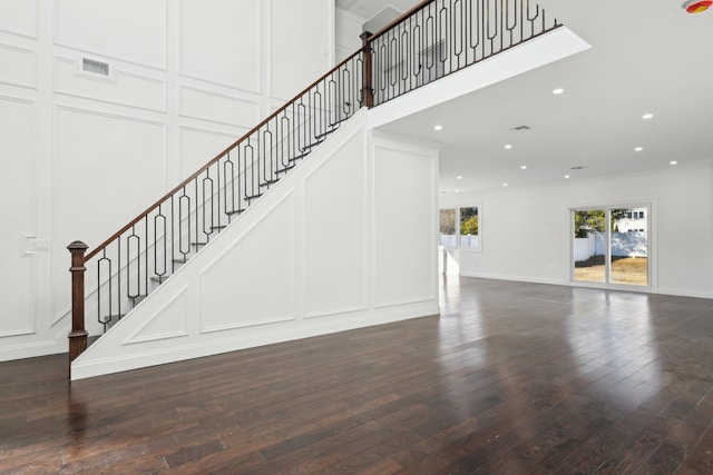 430 Wellington Rd, East Meadow, NY 11554 - unfurnished living room with visible vents, dark wood-style floors, stairway, a decorative wall, and recessed lighting