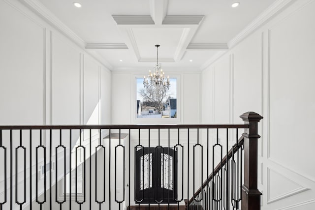 430 Wellington Rd, East Meadow, NY 11554 - hallway featuring crown molding, coffered ceiling, a notable chandelier, and a decorative wall