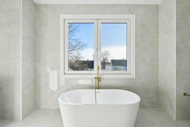 430 Wellington Rd, East Meadow, NY 11554 - bathroom featuring a freestanding tub, tile patterned flooring, and tile walls
