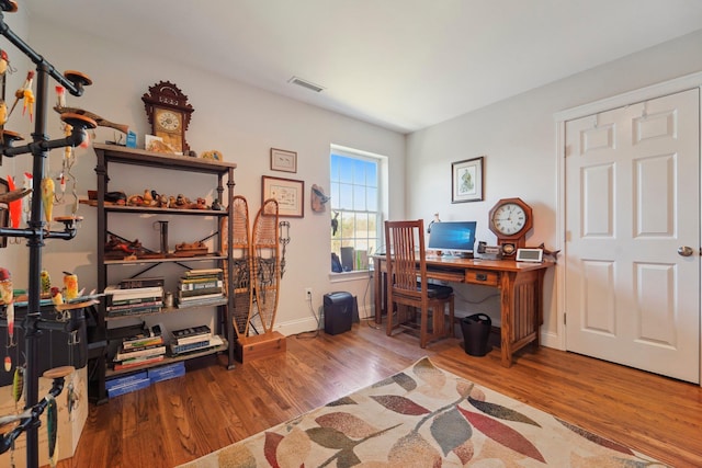 home office with visible vents, baseboards, and wood finished floors