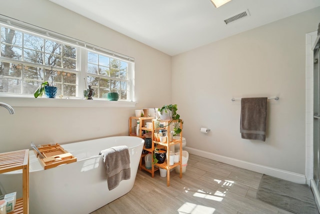 bedroom featuring visible vents, baseboards, and wood finished floors