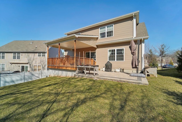 rear view of property featuring a deck and a yard