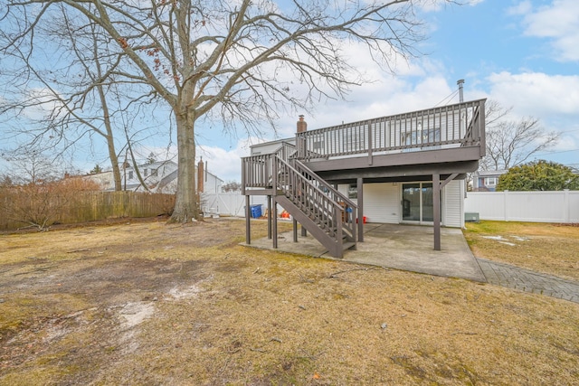 back of property featuring a fenced backyard, a chimney, stairs, a wooden deck, and a patio area