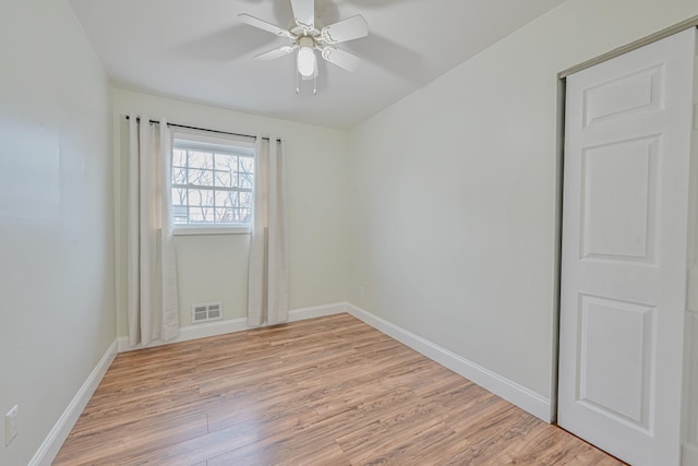 unfurnished room featuring ceiling fan, light wood-style flooring, visible vents, and baseboards