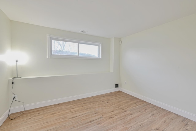 unfurnished room with light wood-style flooring, visible vents, and baseboards