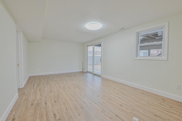 unfurnished room with light wood-type flooring, visible vents, and baseboards