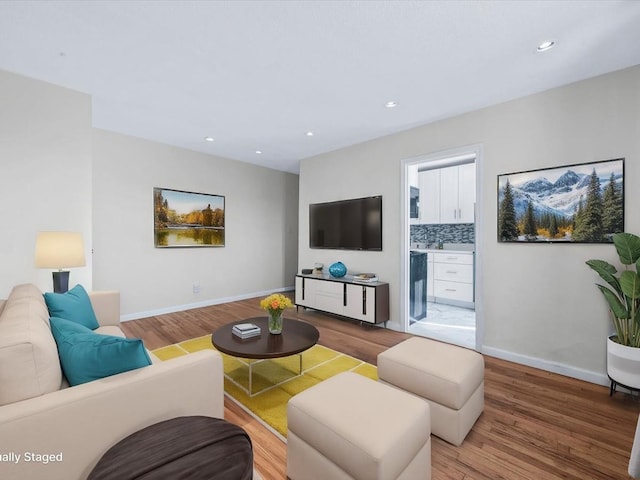 living room featuring recessed lighting, baseboards, and wood finished floors