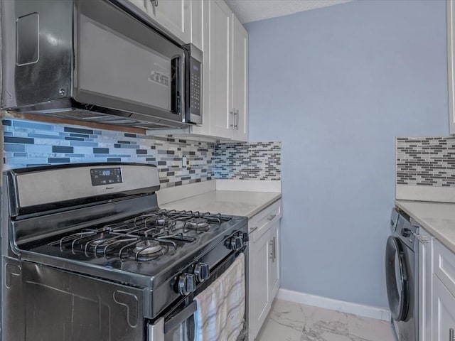 kitchen with black microwave, white cabinets, marble finish floor, washer / clothes dryer, and stainless steel range with gas stovetop