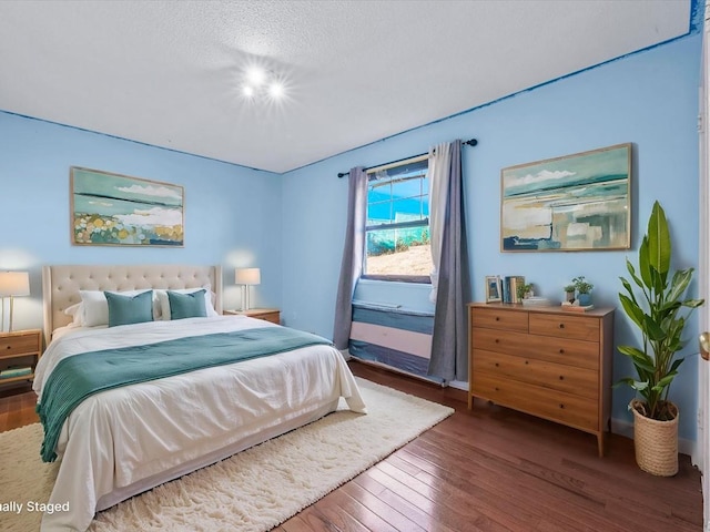 bedroom with a textured ceiling and dark wood-style flooring