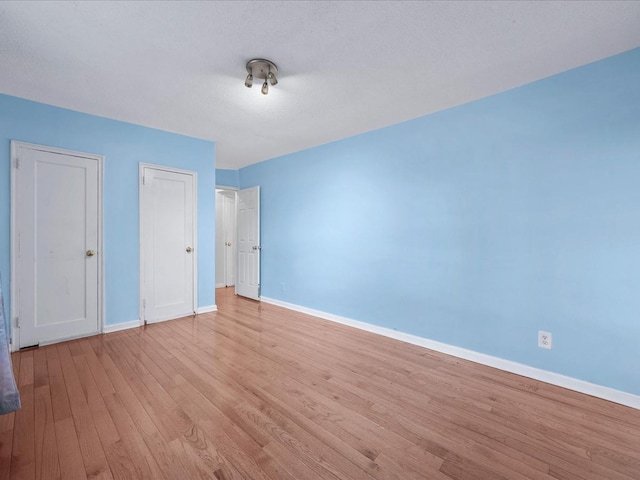 unfurnished bedroom with light wood-type flooring and baseboards