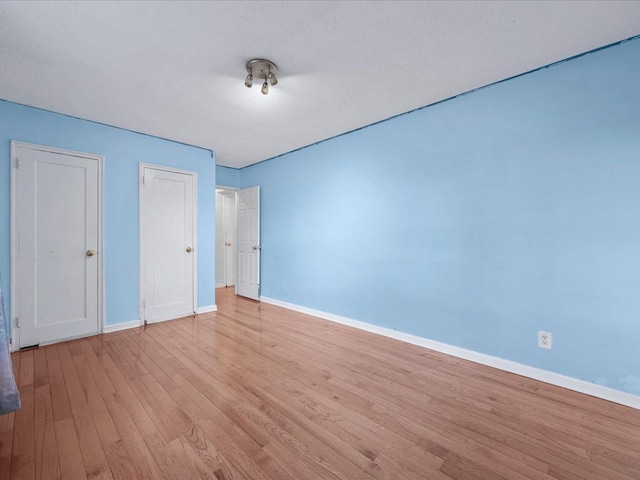 unfurnished bedroom with light wood-style flooring and baseboards