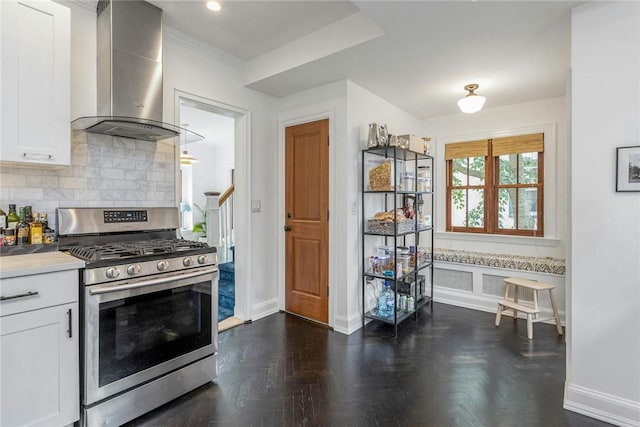 kitchen with gas range, tasteful backsplash, white cabinets, and wall chimney range hood