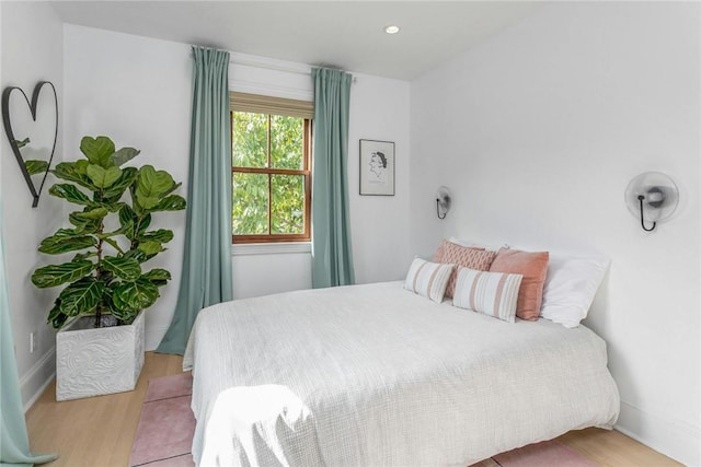 bedroom with baseboards, wood finished floors, and recessed lighting